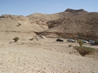 Jubaila (below vehicles, Arab D represented by horizontal beds above veivles and Arab C by the chaotic beds forming the main part of the hill
